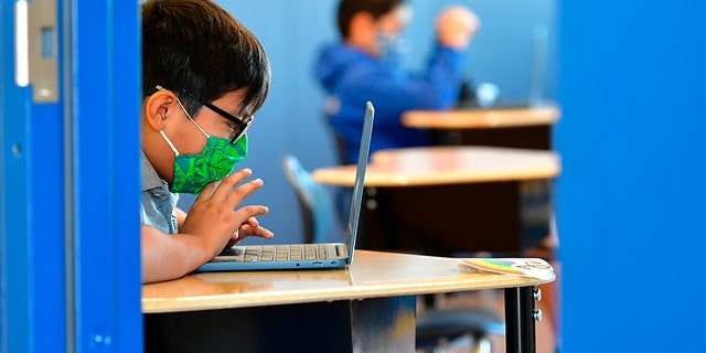 Students work on their laptops at St. Joseph's Catholic School in La Puente, Calif., November 16, 2020. 