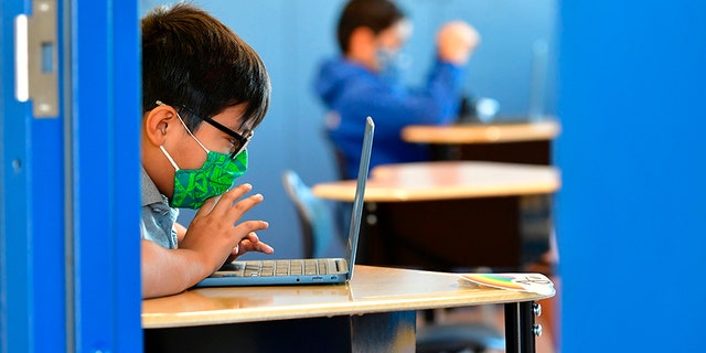 Students work on their laptop computers at St. Joseph Catholic School in La Puente, Calif., on Nov. 16, 2020.