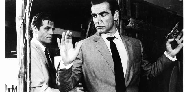 Sean Connery held at gunpoint by Jack Lord in a scene from the film 'James Bond: Dr. No', 1962.