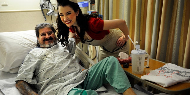 Tito Suazo, who served in the Air Force, gets a hug from Gina Elise, Founder of the non-profit organization, Pin-Ups For Vets, during her visit to the Denver VA Medical Center Wednesday, December 14, 2011.