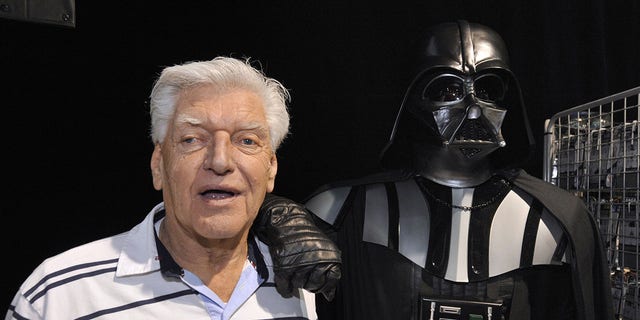English actor David Prowse, who played the character of Darth Vader in the first "Star wars" trilogy, poses with a fan dressed in Darth Vader costume during a Star Wars convention on April 27, 2013 in Cusset, France.  (Getty Images)