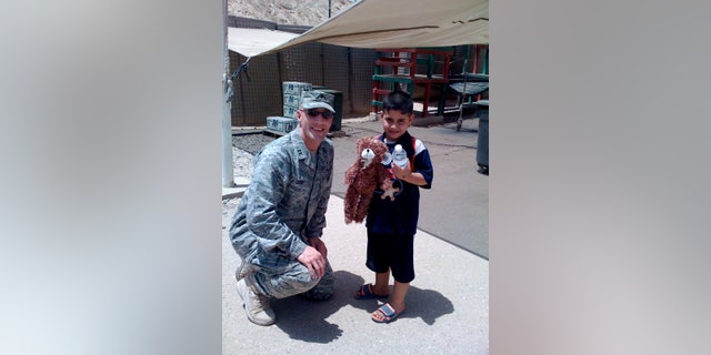 Chaplain Cizek handing out stuffed animal to Iraq child