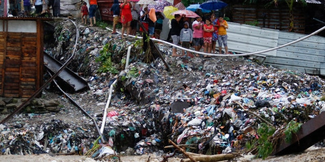 People watch the waters of the Rio Bermejo in the wake of Hurricane Iota in San Pedro Sula, Honduras, Tuesday, Nov. 17, 2020. Hurricane Iota tore across Nicaragua on Tuesday, hours after roaring ashore as a Category 4 storm along almost exactly the same stretch of the Caribbean coast that was recently devastated by an equally powerful hurricane.