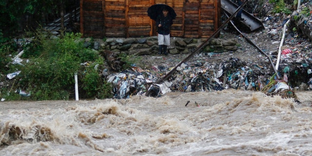 A man watches the rising water of the Rio Bermejo in the wake of Hurricane Iota in San Pedro Sula, Honduras, Tuesday, Nov. 17, 2020.