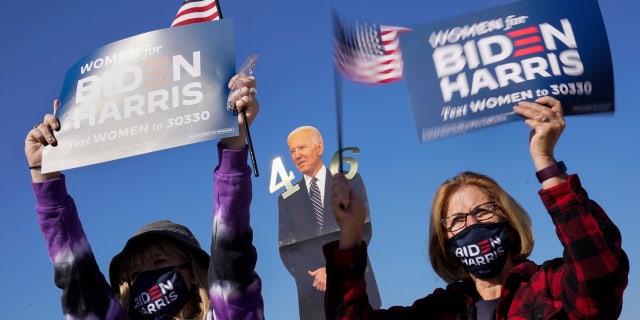 Supporters listen as Democratic presidential candidate former Vice President Joe Biden speaks at a rally at the Iowa State Fairgrounds in Des Moines, Iowa, Friday, Oct. 30, 2020.