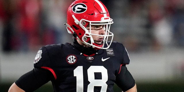 Georgia quarterback JT Daniels looks for a play call from the sideline during the first half of the team's NCAA college football game against Mississippi State, Saturday, Nov. 21, 2020, in Athens, Ga. (AP Photo/Brynn Anderson)