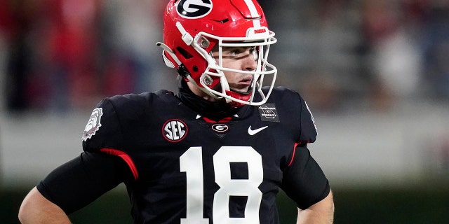 Georgia quarterback JT Daniels looks for a play call from the sideline during the first half of the team's NCAA college football game against Mississippi State, Sabato, Nov. 21, 2020, ad Atene, Ga. (AP Photo / Brynn Anderson)