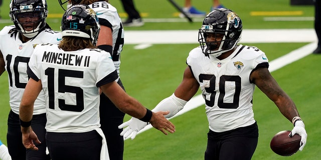 Jacksonville Jaguars running back James Robinson, right, celebrates his rushing touchdown with Gardner Minshew (15) during the first half of an NFL football game against the Los Angeles Chargers Sunday, Oct. 25, 2020, in Inglewood, Calif.