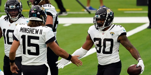 Jacksonville Jaguars running back James Robinson, right, celebrates his rushing touchdown with Gardner Minshew (15) during the first half of an NFL football game against the Los Angeles Chargers Sunday, Oct. 25, 2020, in Inglewood, Calif.