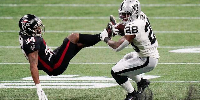 Las Vegas Raiders running back Josh Jacobs (28) hits Atlanta Falcons defensive back Darqueze Dennard (34) during the first half of an NFL football game, 일요일, 11 월. 29, 2020, 애틀랜타. (AP 사진 / Brynn Anderson)