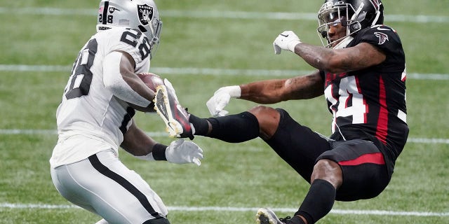 Las Vegas Raiders running back Josh Jacobs (28) hits Atlanta Falcons defensive back Darqueze Dennard (34) during the first half of an NFL football game, 일요일, 11 월. 29, 2020, 애틀랜타. (AP Photo/John Bazemore)