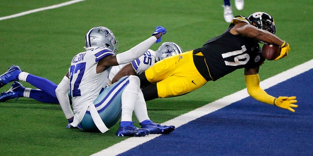 Dallas Cowboys' Donovan Wilson, left front, and Xavier Woods left rear, are unable to stop Pittsburgh Steelers wide receiver JuJu Smith-Schuster (19) from scoring a touchdown after catching a pass in the second half of an NFL football game in Arlington, Texas, Sunday, Nov. 8, 2020. (AP Photo/Michael Ainsworth)