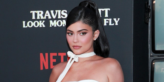 Kylie Jenner posted a pair of seductive photos on Monday from her living room in a skin-tight, strapless dress.