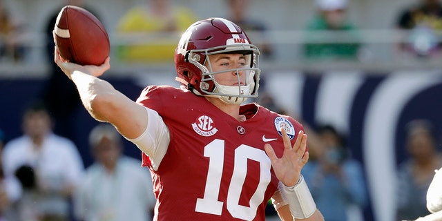 FILE- In this Jan. 1, 2020, file photo, Alabama quarterback Mac Jones (10) throws a pass during the second half of the Citrus Bowl NCAA college football game against Michigan in Orlando, Fla. Alabama quarterback Mac Jones and Auburn's Bo Nix have taken different paths to their starting jobs. Now, they'll lead their teams into the Iron Bowl for the second straight year. (AP Photo/John Raoux, File)