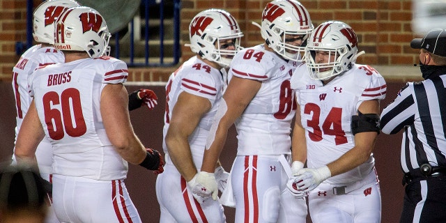 Wisconsin fullback Mason Stokke (34) celebrates his touchdown with teammates in the first quarter of an NCAA college football game against Michigan in Ann Arbor, Ek., Saterdag, Nov.. 14, 2020. (AP Photo/Tony Ding)