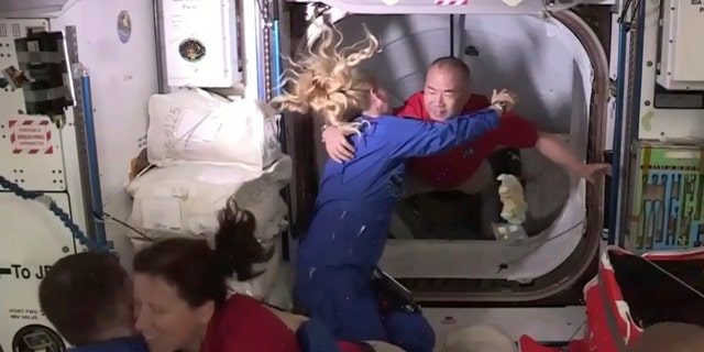 In this frame grab from NASA TV, astronaut Soichi Noguchi, background right, is greeted by astronaut Kate Rubins, as he enters the International Space Station from the vestibule between the SpaceX Dragon capsule and the ISS, early Tuesday, Nov. 17, 2020.