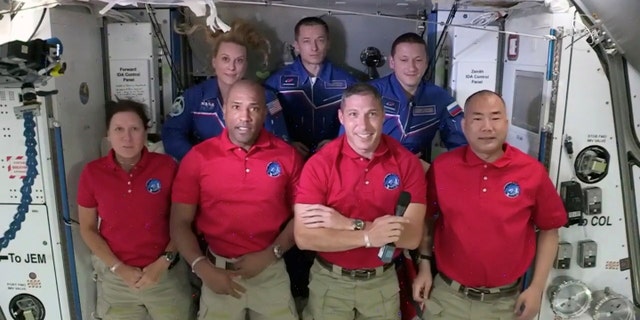 In this frame grab from NASA TV, SpaceX Dragon crew, from front left to right, Shannon Walker, Victor Glover, Mike Hopkins and Soichi Noguchi stand with International Space Station crew Kate Rubins, from back left, Expedition 64 commander Sergey Ryzhikov and Sergey Kud-Sverchkov during a welcome ceremony, early Tuesday, Nov. 17, 2020. The Dragon arrived and docked at the ISS late Monday. (NASA TV via AP)