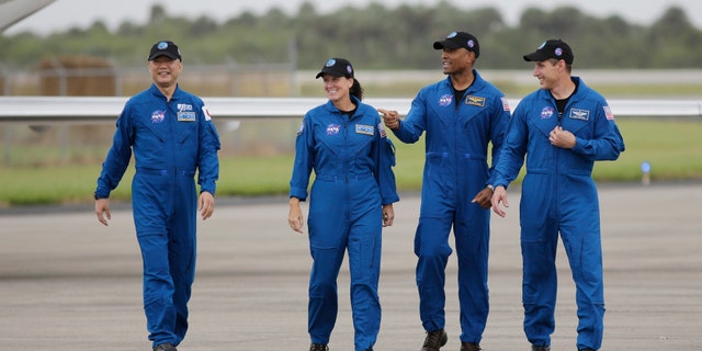 Astronaut Soichi Noguchi, of Japan, from left, NASA Astronauts Shannon Walker, Victor Glover and Michael Hopkins walk after arriving at Kennedy Space Center, Sunday, Nov. 8, 2020, in Cape Canaveral, Fla. The four astronauts will fly on the SpaceX Crew-1 mission to the International Space Station scheduled for launch on Nov. 14, 2020