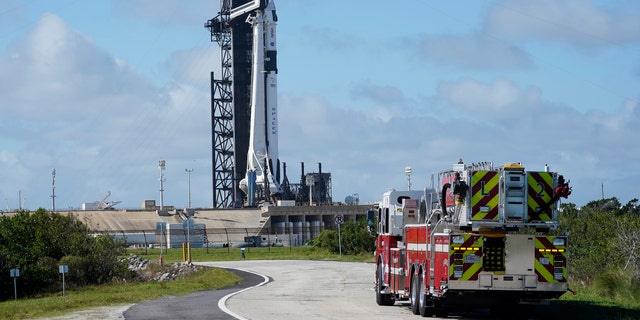 NASA firefighters drive down the road outside the fence near a SpaceX Falcon 9 rocket, with the company's Crew Dragon capsule attached, sits on the launch pad at Launch Complex 39A on Friday the 13th November 2020, at the Kennedy Space Center in Cape Canaveral, Florida