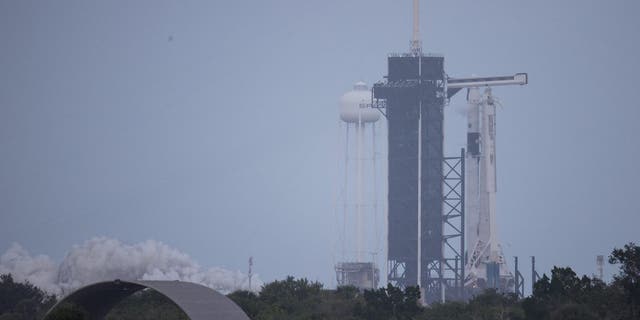 A SpaceX Falcon 9 rocket with the firm's Crew Dragon spacecraft onboard on the launch pad at Launch Complex 39A at Kennedy Space Center in Florida. The rocket was photographed during a short static fire test ahead of the Crew-1 mission.