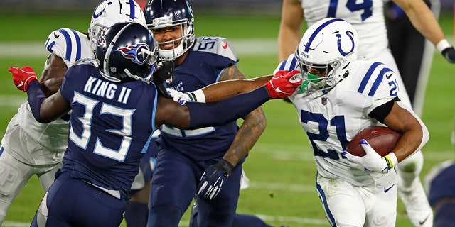 Tennessee Titans cornerback Desmond King (33) reaches for Indianapolis Colts running back Nyheim Hines (21) in the first half of an NFL football game Thursday, Nov. 12, 2020, in Nashville, Tenn. (AP Photo/Wade Payne)