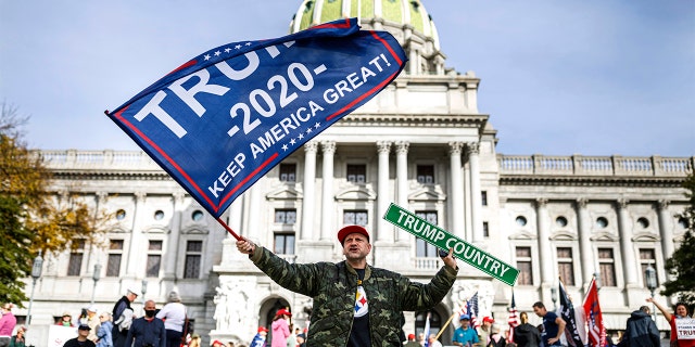 A man waves a flag at a pro-Trump rally at the Pennsylvania state Capitol in Harrisburg, Pa., Friday, Nov. 5, 2020. (Associated Press)