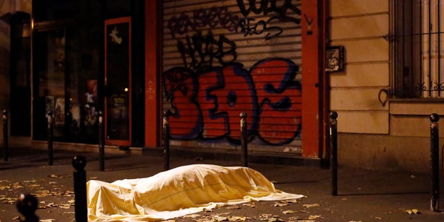 FILE - In this Nov. 13, 2015 파일 사진, a victim of an attack in Paris lays dead outside the Bataclan theater in Paris. In the aftermath of the horrifying attacks in Paris on Nov. 13, 2015, people were so jittery that some loud, unremarkable noises were enough to send some people scurrying for help. Some experts say it will take months for Europeans to adapt to life after the paris attacks. (AP Photo/Jerome Dela파일ile)
