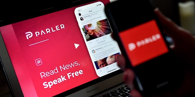 This illustration picture shows social media application logo from Parler displayed on a smartphone with its website in the background in Arlington, Virginia on July 2, 2020.
