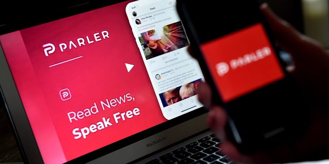 This illustration picture shows social media application logo from Parler displayed on a smartphone with its website in the background in Arlington, Virginia on July 2, 2020.