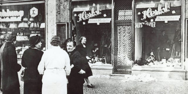 A group of people stand outside a Jewish-owned shop in an unnamed German town in November 1938, after the Kristallnacht, when Nazis thugs burned and plundered hundreds of Jewish homes, shops and synagogues across the country. (AP Photos)