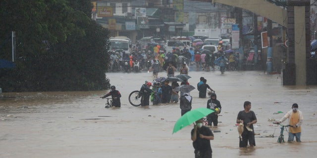 On Thursday, November 12, 2020, due to Typhoon Vamco, residents walked on a flooded road in Marikina, Philippines.