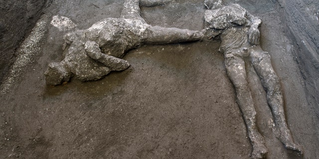 The casts of what are believed to have been a rich man and his male slave fleeing the volcanic eruption of Vesuvius nearly 2,000 years ago, are seen in what was an elegant villa on the outskirts of the ancient Roman city of Pompeii destroyed by the eruption in 79 A.D., where they were discovered during recent excavations, Pompeii archaeological park officials said Saturday, Nov. 21, 2020.