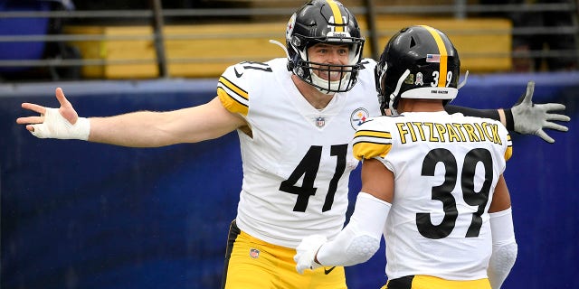 Pittsburgh Steelers linebacker Robert Spillane, left, celebrates with free safety Minkah Fitzpatrick after scoring on an interception of a pass from Baltimore Ravens quarterback Lamar Jackson, not visible, during the first half of an NFL football game, Sunday, Nov. 1, 2020, in Baltimore. (AP Photo/Nick Wass)