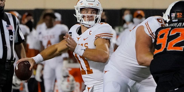 Texas quarterback Sam Ehlinger (11) throws a touchdown pass in overtime of an NCAA college football game against Oklahoma State in Stillwater, Okla., Sabato, Ott. 31, 2020. (AP Photo/Sue Ogrocki)