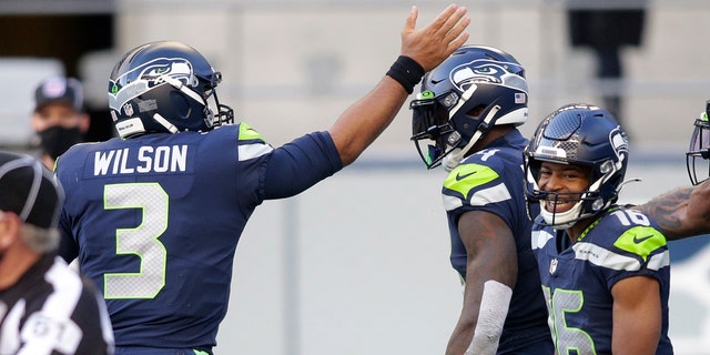 Seattle Seahawks quarterback Russell Wilson (3) celebrates with wide receiver DK Metcalf, center, after Wilson passed to Metcalf for a touchdown against the San Francisco 49ers during the first half of an NFL football game, Sunday, Nov. 1, 2020, in Seattle. (AP Photo/Scott Eklund)