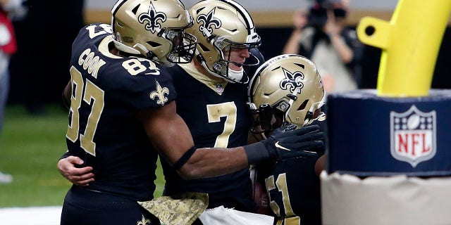 New Orleans Saints quarterback Taysom Hill (7) celebrates his touchdown carry with tight end Jared Cook (87) and center Cesar Ruiz (51) in the second half of an NFL football game in New Orleans, Sunday, Nov. 22, 2020. (AP Photo/Brett Duke)