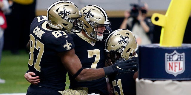 New Orleans Saints quarterback Taysom Hill (7) celebrates his touchdown carry with tight end Jared Cook (87) and center Cesar Ruiz (51) in the second half of an NFL football game in New Orleans, Sunday, Nov. 22, 2020. (AP Photo/Brett Duke)