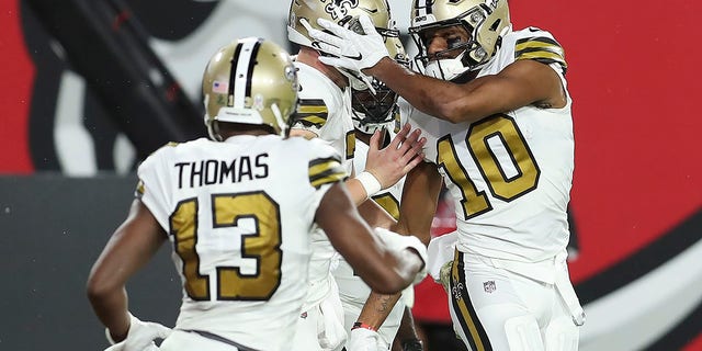 New Orleans Saints wide receiver Tre'Quan Smith (10) celebrates with teammates, including wide receiver wide receiver Michael Thomas (13) after scoring against the Tampa Bay Buccaneers during the first half of an NFL football game Sunday, Nov. 8, 2020, in Tampa, Fla. (AP Photo/Mark LoMoglio)