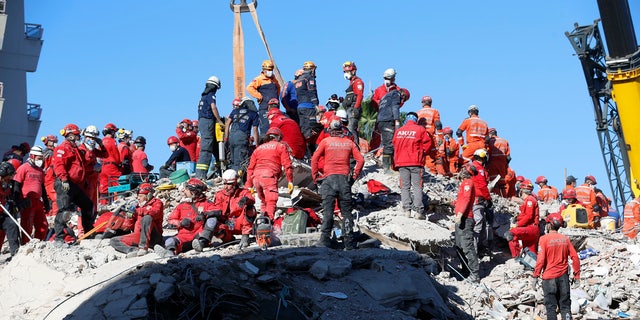 Members of rescue services search in the debris of a collapsed building for survivors in Izmir, Turkey, early Sunday, Nov. 1, 2020.