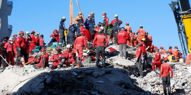 Members of rescue services search in the debris of a collapsed building for survivors in Izmir, 터키, early Sunday, 11 월. 1, 2020.