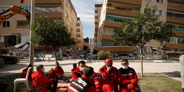 Members of rescue services take a break during search operations in the debris of a collapsed building for survivors in Izmir, 터키, 일요일, 11 월. 1, 2020.