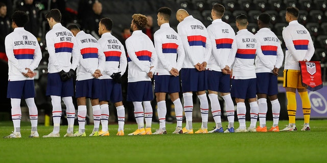 US team members stand for their national anthem before the international friendly soccer match between Wales and USA at Liberty Stadium in Swansea, Wales, Thursday, Nov. 12, 2020. (AP Photo/Kirsty Wigglesworth)