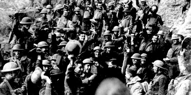 American troops cheer after hearing the news that the Armistice has been signed, ending World War I in November 1918. They are located on the front northeast of St. Mihiel, France. Similar celebrations took place all along the line where the Americans were engaged in an offensive. (AP photo)