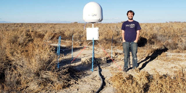 This undated photo provided by Caltech shows radio astronomer Christopher Bochenek with a STARE2 station he developed near the town of Delta, Utah. On Wednesday, Nov. 4, 2020, astronomers say they used this system and a Canadian observatory to trace an April 2020 fast cosmic radio burst to our own galaxy.