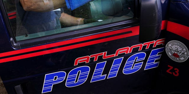A sanitation company employee cleans an Atlanta Police Department prisoner transport van in Atlanta, Georgia, on June 18, 2020.