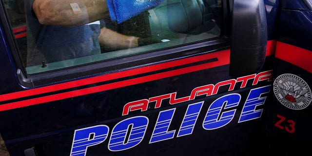 A sanitation company employee cleans an Atlanta Police Department prisoner transport van in Atlanta, Georgia, on June 18, 2020.