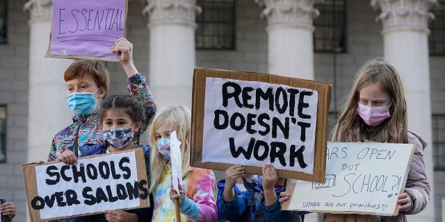 Öğrenciler, New York'ta 14 Kasım 2020 Cumartesi günü New York Belediye Başkanı Bill de Blasio'yu okulları açık tutmaya çağırmak için bir miting sırasında gösteri yapıyor.