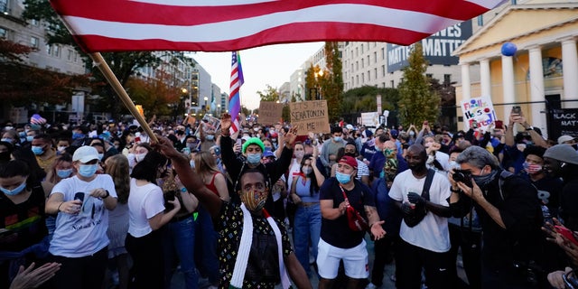 People gather in Black Lives Matter Plaza on Nov. 7, 2020, to celebrate President-elect Joe Biden's win over President Donald Trump to become the 46th president of the United States. (AP Photo/Alex Brandon, File)