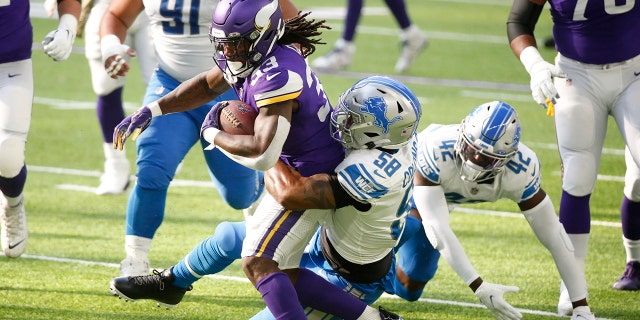 Minnesota Vikings running back Dalvin Cook (33) is tackled by Detroit Lions linebacker Jamie Collins Sr. (58) durante la prima metà di una partita di football della NFL, Domenica, Nov. 8, 2020, in Minneapolis. (AP Photo/Bruce Kluckhohn)