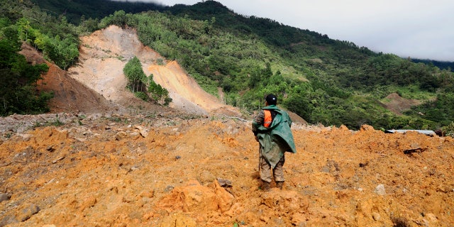 A member of the search and rescue team is looking for survivors after the devastation caused by a massive landslide caused by rain in the village of Queja, in Guatemala, Saturday, November 7, 2020, after the storm tropical Eta.